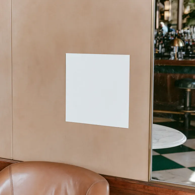Blank white sheet on a leather-panelled wall